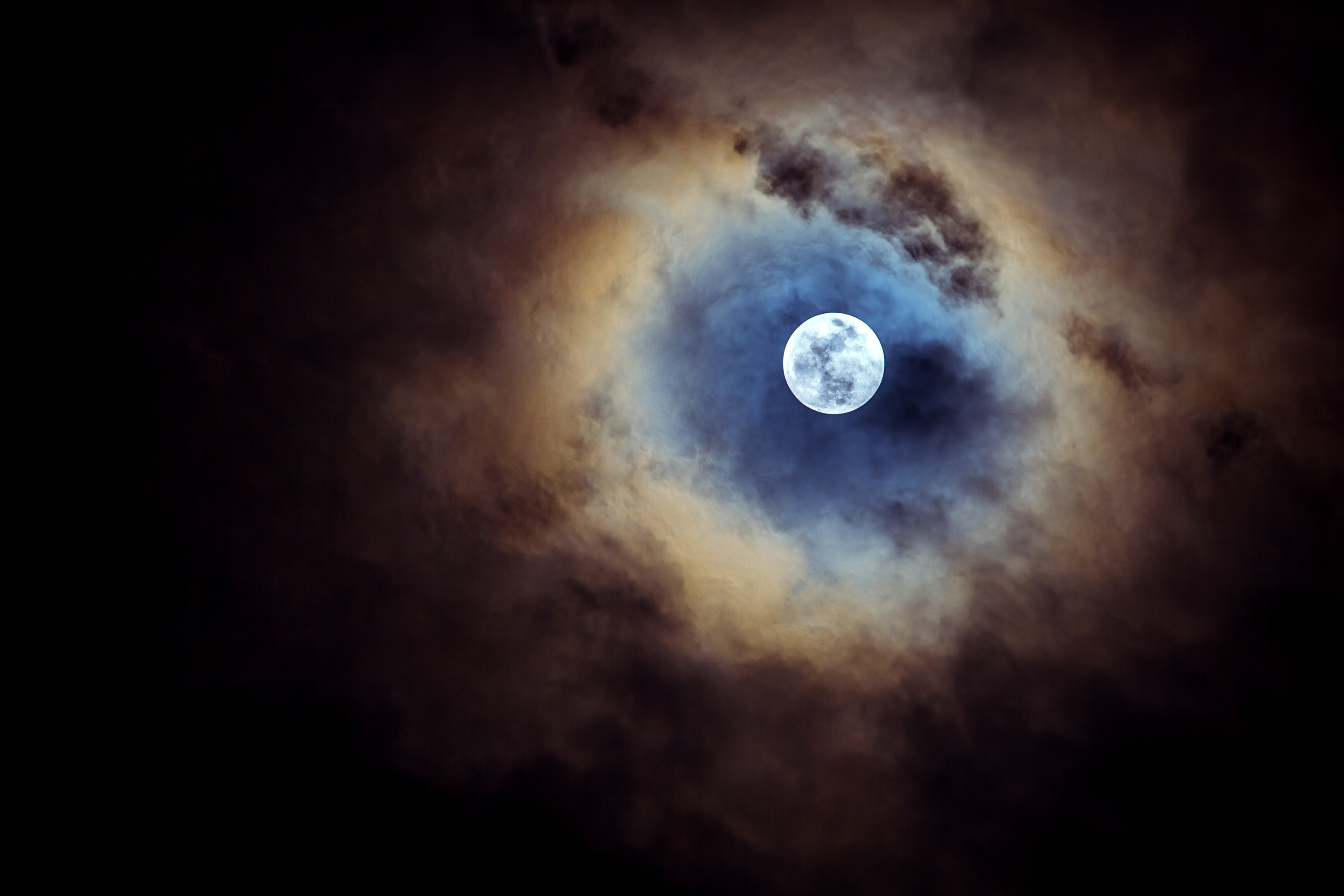 Full moon on cloudy day.